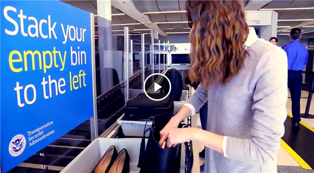 Passenger unloads her belongings into bins for the automated screening lanes